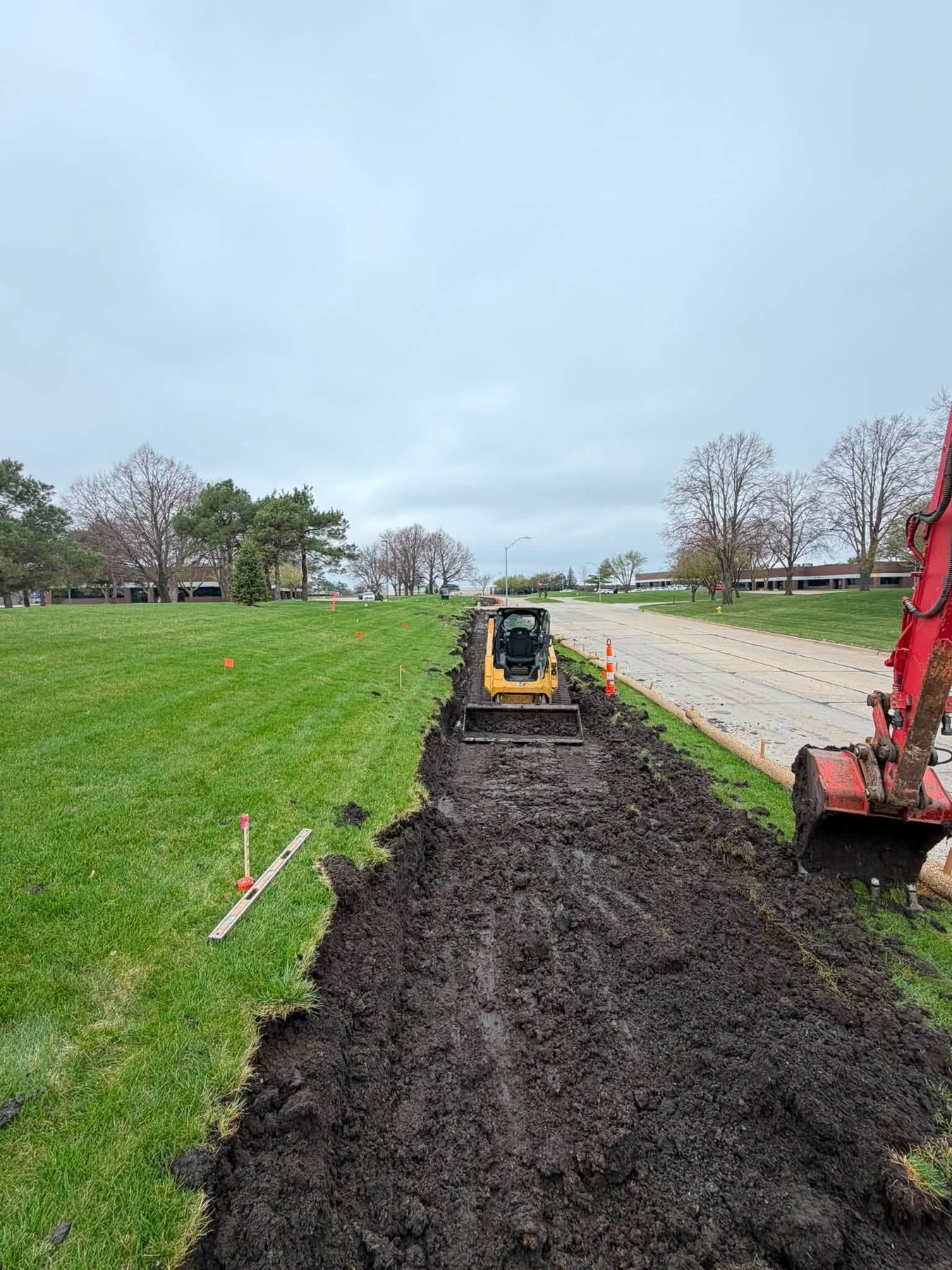 Excavator and skid steer performing site work